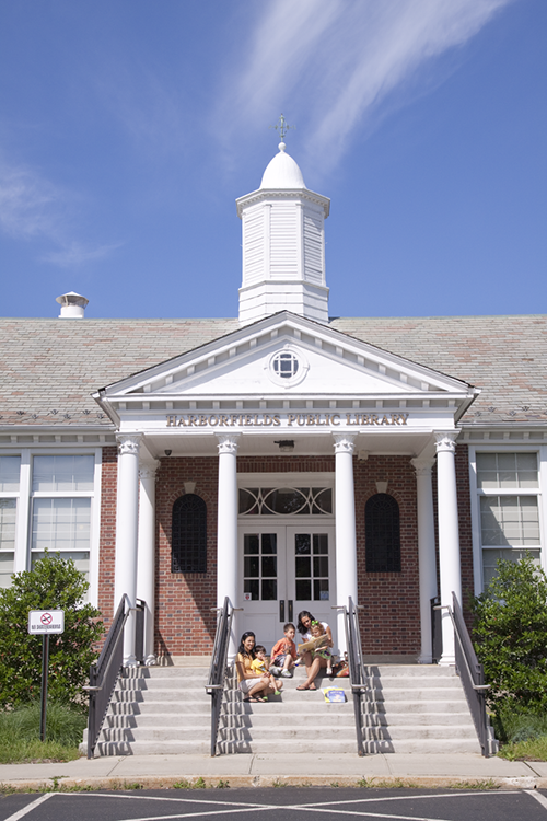 Harborfields public Library entrance with family sitting on the steps